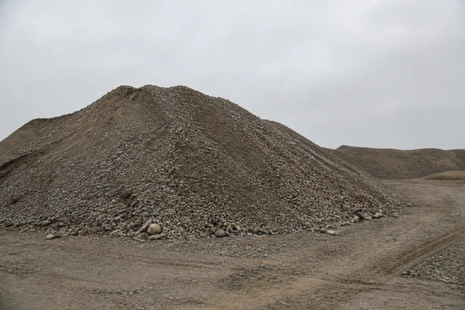 An aggregate stockpile on a working site, outlined by a measurement region and labelled with a computed volume